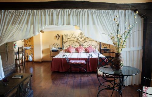 Un dormitorio con una cama con almohadas rosas. en Hotel Rural Los Angeles en Las Hurdes, en Vegas de Coria