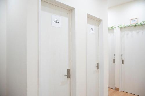a row of white doors in a room at Upper Hotel Ryogoku in Tokyo