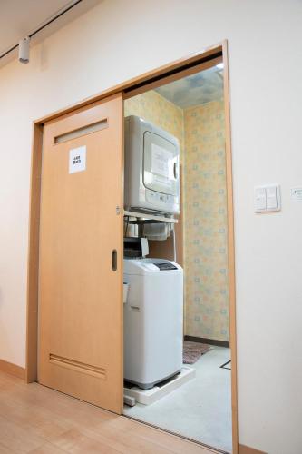 an open door to a room with a computer and a tv at Upper Hotel Ryogoku in Tokyo