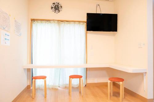 a table and two stools in front of a window at Upper Hotel Ryogoku in Tokyo