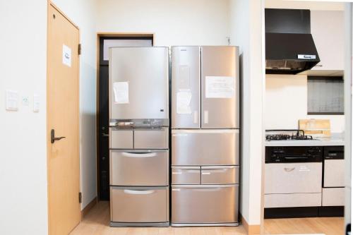 a kitchen with two stainless steel refrigerators at Upper Hotel Ryogoku in Tokyo