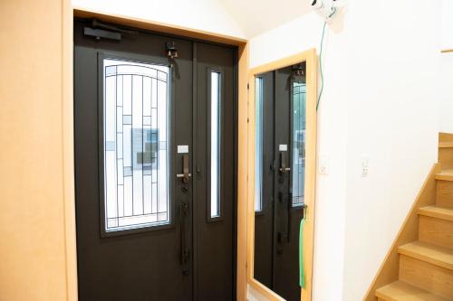 a black door with two windows in a hallway at Upper Hotel Ryogoku in Tokyo