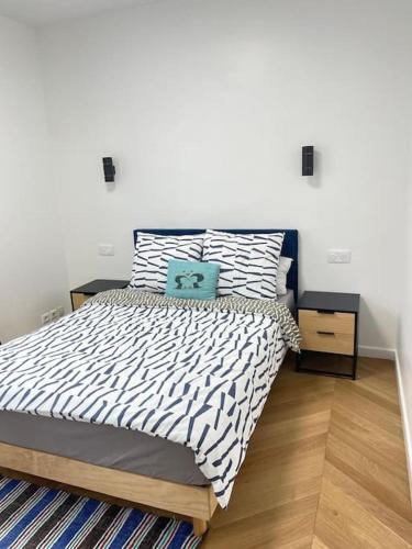 une chambre avec un lit avec une couette noire et blanche dans l'établissement New appartement charmant et lumineux, à Paris