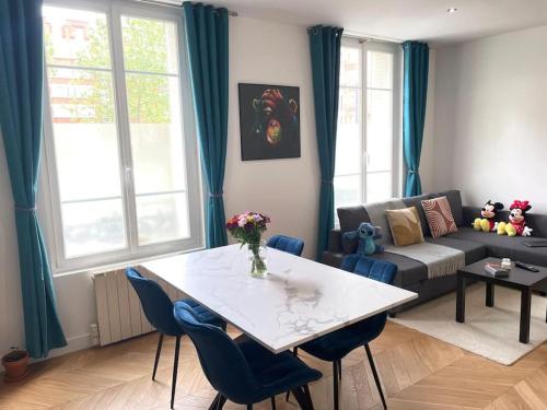 un salon avec une table et un canapé dans l'établissement New appartement charmant et lumineux, à Paris