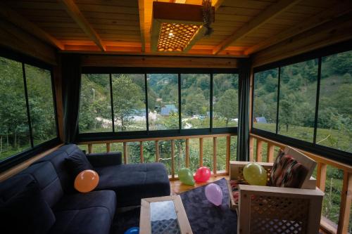 a living room with a blue couch and some windows at Efulim Apart in Çamlıhemşin