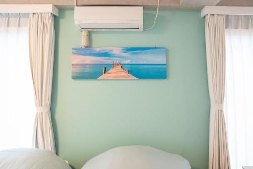 a bedroom with a painting of a pier on the wall at Upper Hotel Ishihara in Tokyo