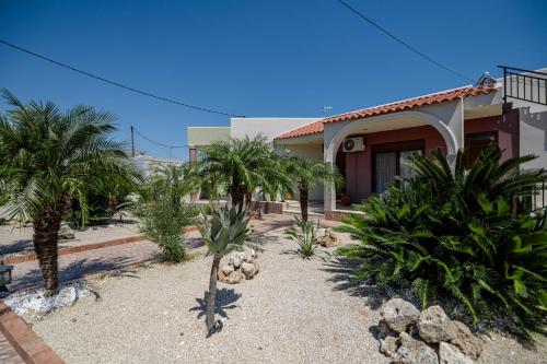 a house with palm trees in front of it at Kira's Lovely Villa Massari in Haraki