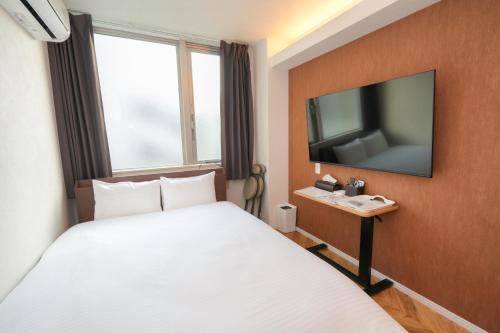 CoCo Park في كاجوشيما: غرفة فندق بها سرير وتلفزيون بشاشة مسطحة