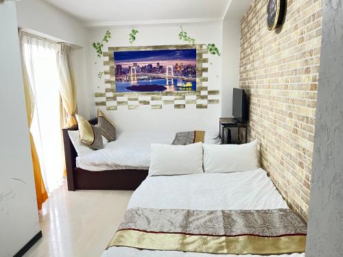 two beds in a room with a brick wall at 403 Oshiage sta 3mins walk! Wi-Fi & Elevator 4pax in Tokyo