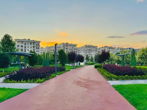 a pathway in a park with buildings in the background at Apartment in Boulevard in Tashkent