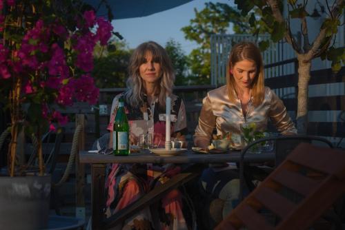 two women sitting at a table with drinks at Hotell Persnäs in Persnäs