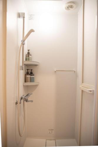 a bathroom with a shower with a shower head at Upper Hotel Ishihara in Tokyo