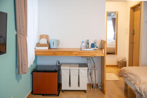 a room with a table and a bed and a mirror at Upper Hotel Ishihara in Tokyo