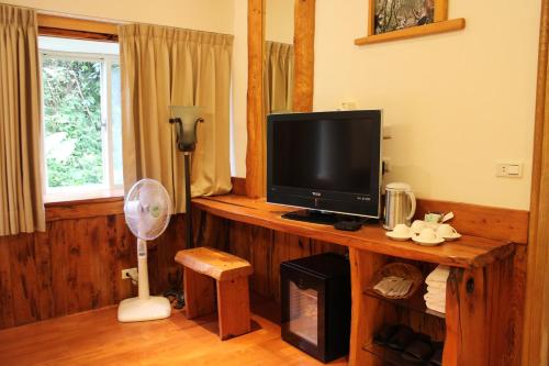 a living room with a television on a wooden table at Shangrila Leisure Farm in Dongshan