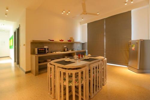 a kitchen with a table and a refrigerator at Wonmi Residency in Galle