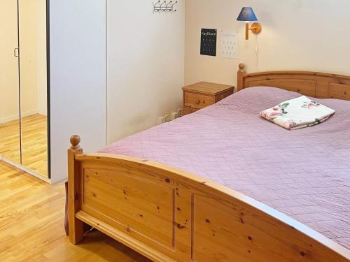 una camera con letto in legno e coperta viola di 4 star holiday home in Sturkø a Karlskrona