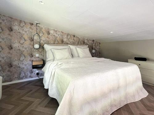 a bedroom with a white bed and a stone wall at 4 star holiday home in LJUNGBY in Ljungby