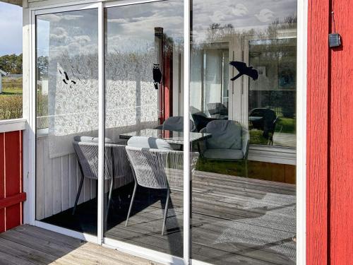 a glass door of a porch with a table and chairs at Beautiful holiday home near sea-By Traum in Laholm