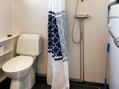 a bathroom with a toilet and a shower curtain at Beautiful holiday home near sea-By Traum in Laholm