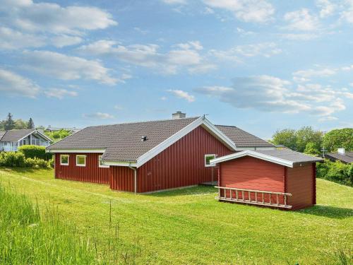 a red barn sitting on top of a lush green field at 5 star holiday home in Allinge-By Traum in Allinge