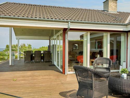 an open patio with chairs on a wooden deck at 5 star holiday home in Allinge-By Traum in Allinge