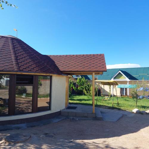 a gazebo with a roof and a swing at Guest house and yurt camp Svetlana in Bokonbayevo