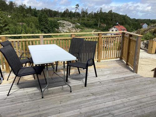 a white table and chairs on a wooden deck at 4 person holiday home in Nösund in Nösund
