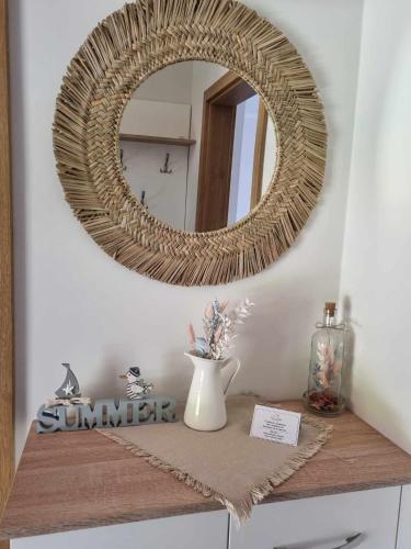 a mirror on top of a table with a vase at Villa V53 Siófok in Siófok