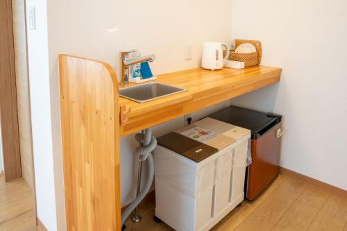 a kitchen counter with a sink and a box under it at Upper Hotel Ishihara in Tokyo