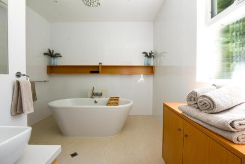 a bathroom with a white tub and a sink and towels at Tanunda House - Luxury 5 BR in Barossa Wine Region in Tanunda