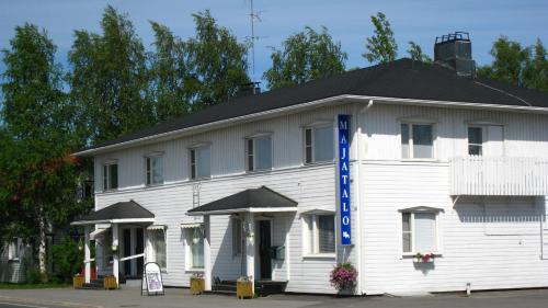 a white building with a black roof at Guesthouse Golden Goose in Kittilä