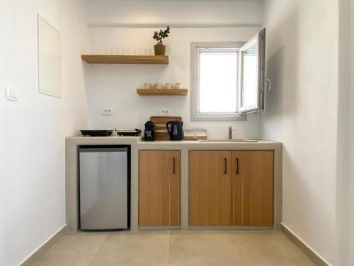 a small kitchen with a sink and a window at Nohēme Luxury Suites in Vourvoulos
