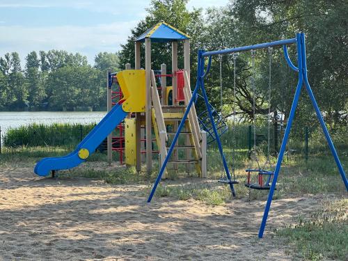 a playground with two swings and a slide at Apartament Jerzyn in Jerzyn