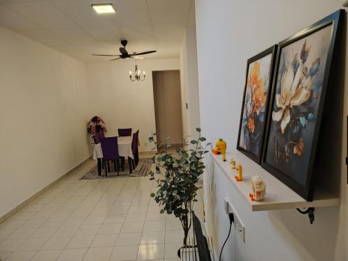 a hallway with a living room with paintings on the wall at Orked Homestay Seri Iskandar in Seri Iskandar