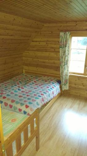 a bedroom with a bed in a log cabin at Aratsaare Holiday home in Kõpu