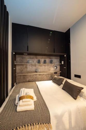 a bedroom with a large white bed with a wooden headboard at El Bosque Del Puerto in Gijón
