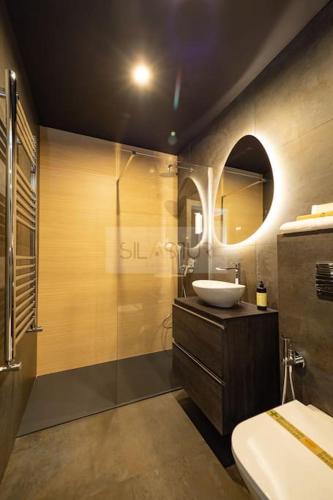 a bathroom with a sink and a glass shower at El Bosque Del Puerto in Gijón