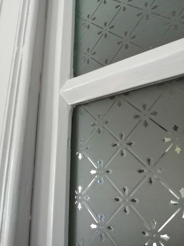 a view of a window with a white door with flowers at Plomari Nomad House in Plomarion