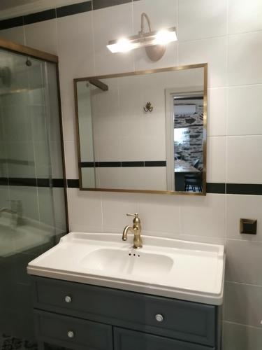 a bathroom with a sink and a mirror at Plomari Nomad House in Plomarion