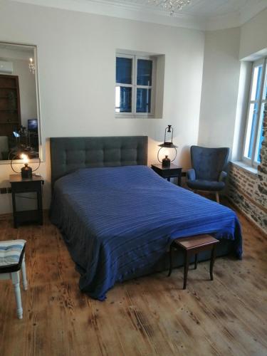 a bedroom with a large bed with a blue blanket at Plomari Nomad House in Plomarion