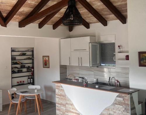 eine Küche mit einer Theke, einem Tisch und Stühlen in der Unterkunft Odmor uz Trebišnjicu in Trebinje