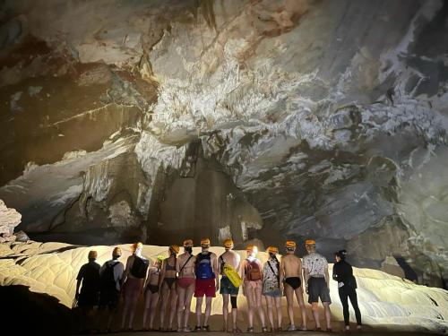 a group of people standing in front of a cave at Phong Nha Dawn Home in Phong Nha