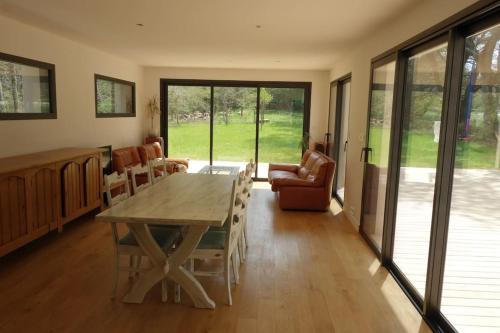 un salon avec une table et des chaises en bois dans l'établissement Carnac au calme, en pleine foret à 400 m d'un bras de mer, à Carnac