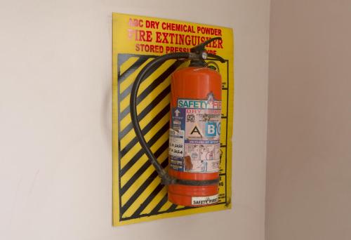 a poster of a fire extinguisher on a wall at Sai Residency in Tiruchchirāppalli