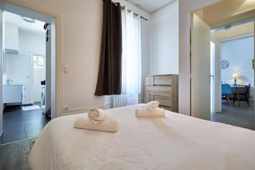 - une chambre avec 2 serviettes sur un lit blanc dans l'établissement Champ Home T2 - 5 mins des Caves de Champagne, à Reims