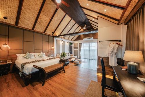 a bedroom with a large bed and a desk and a room at THEE Kashatharn by TH District in Chiang Mai