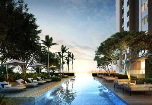 un hotel con piscina con sillas y sombrillas en Sea View Spacious Condo Near Walking Street, en Pattaya South