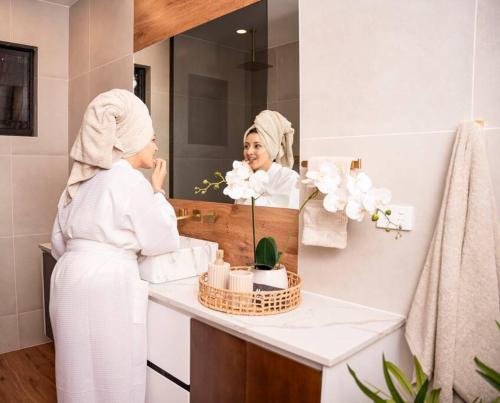 a woman in a bathroom looking at herself in the mirror at Heaven Retreat with Minigolf, pool, fire pit, BBQ in Nadi