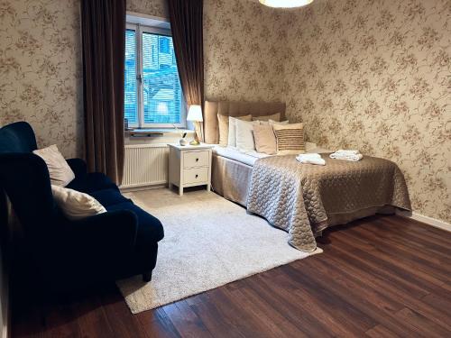 a bedroom with a bed and a chair and a window at Hotel Tre Små Rum in Stockholm