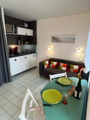 - un salon avec une table verte et un canapé dans l'établissement Appartement residence Castle Beach, à Moëlan-sur-Mer